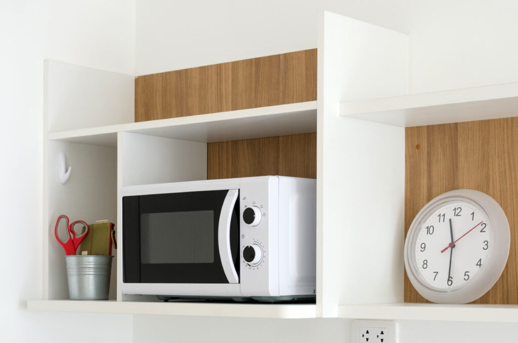 Microwave oven on shelf in pantry